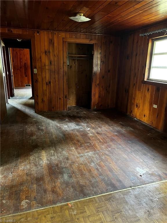 unfurnished room featuring wood ceiling, wooden walls, and dark hardwood / wood-style floors