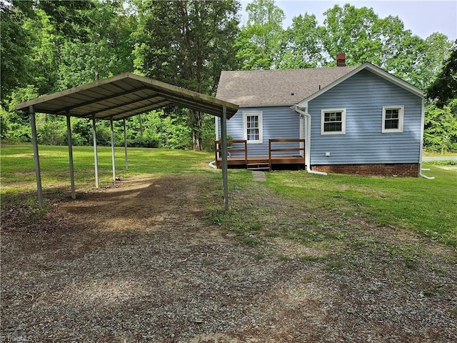 rear view of house featuring a deck, a carport, and a yard