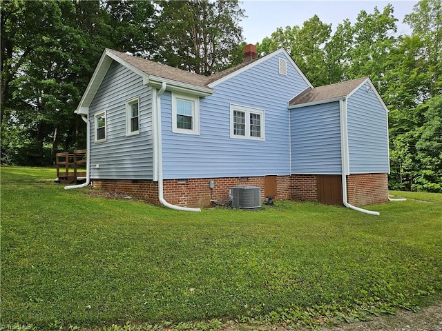 back of property featuring central AC and a yard