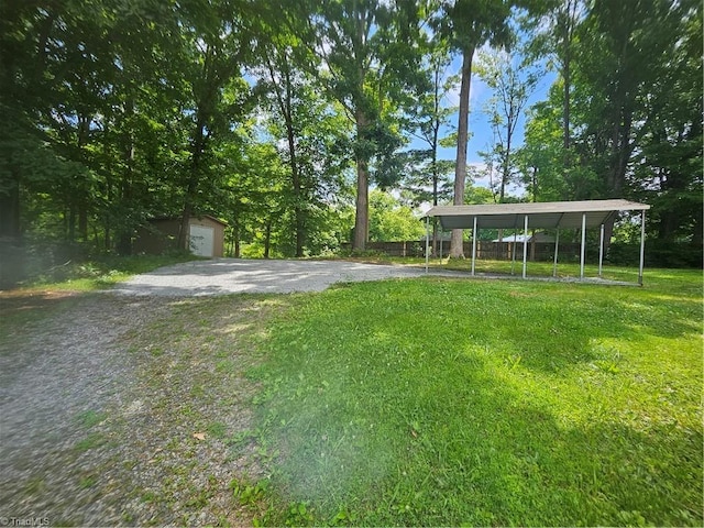 view of yard featuring a carport, a garage, and an outdoor structure