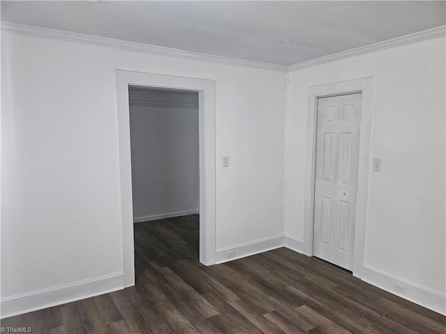 empty room with ornamental molding and dark hardwood / wood-style flooring