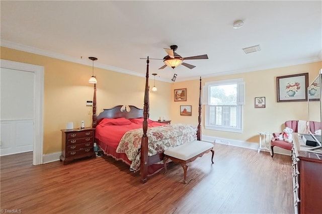 bedroom with ceiling fan, crown molding, and dark wood-type flooring