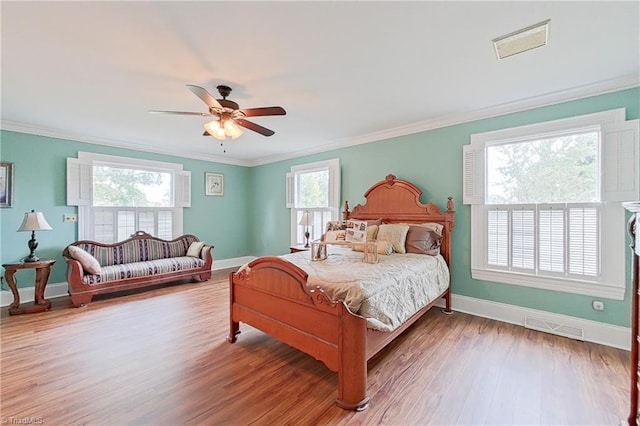 bedroom featuring ceiling fan, ornamental molding, and wood-type flooring