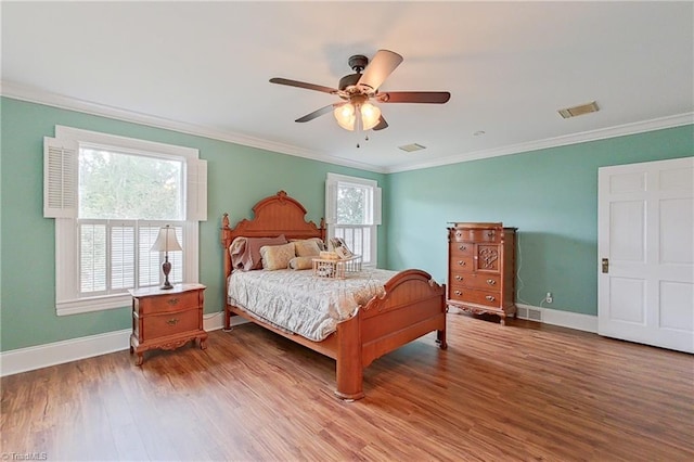 bedroom with crown molding, hardwood / wood-style floors, and ceiling fan