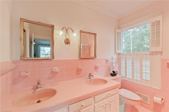 bathroom featuring tile walls, toilet, tasteful backsplash, and dual bowl vanity