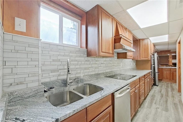 kitchen featuring sink, stainless steel dishwasher, light hardwood / wood-style floors, black electric cooktop, and custom exhaust hood