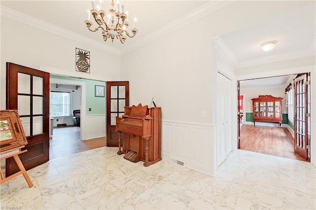 hallway featuring french doors, crown molding, a chandelier, and light tile flooring