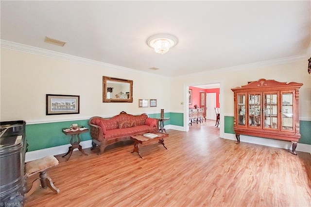 living area with ornamental molding and light wood-type flooring