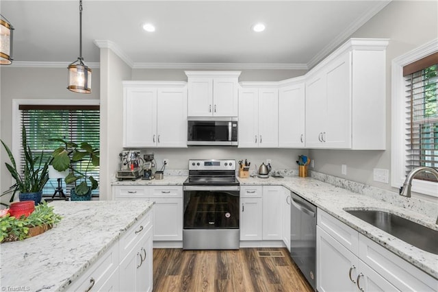 385 Apache Dr, Winston-Salem, NC 27107 - kitchen featuring appliances with stainless steel finishes, a sink, white cabinetry, dark wood-type flooring, and crown molding