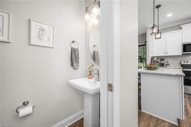 385 Apache Dr, Winston-Salem, NC 27107 - bathroom featuring wood finished floors, ornamental molding, baseboards, a sink, and recessed lighting