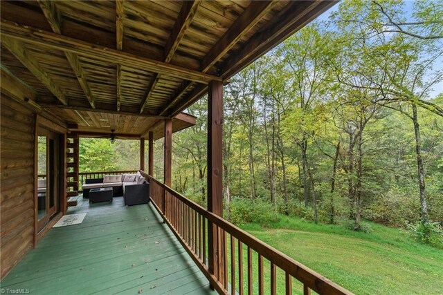 wooden terrace featuring a yard and ceiling fan