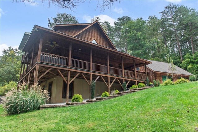 back of property with a wooden deck and a lawn