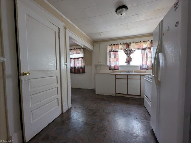 423 Tate St, High Point, NC 27260 - kitchen with freestanding refrigerator, healthy amount of natural light, light countertops, white cabinets, and crown molding