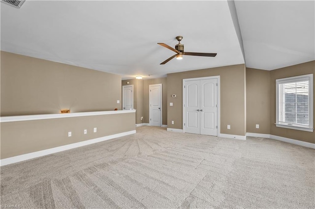 empty room with carpet, visible vents, baseboards, and a ceiling fan