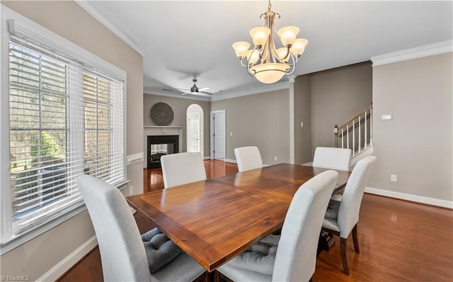 dining area featuring ornamental molding, a multi sided fireplace, and baseboards