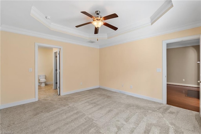 unfurnished bedroom with baseboards, carpet floors, a tray ceiling, and crown molding