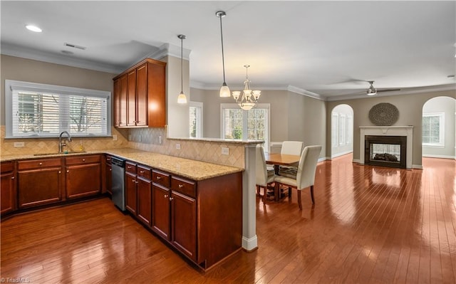 kitchen with a peninsula, dark wood-type flooring, a sink, dishwasher, and tasteful backsplash