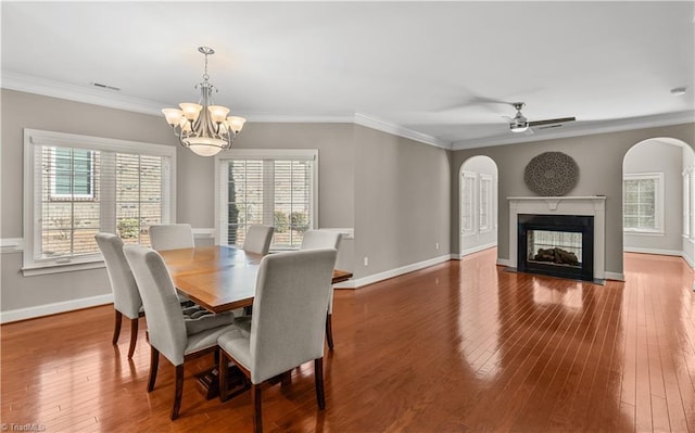 dining space with hardwood / wood-style flooring, visible vents, arched walkways, and ornamental molding