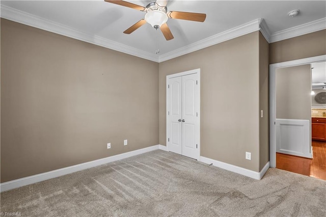 unfurnished bedroom featuring carpet floors, ornamental molding, a closet, and baseboards