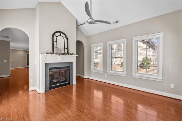 unfurnished living room featuring a wealth of natural light, a fireplace, wood finished floors, and visible vents