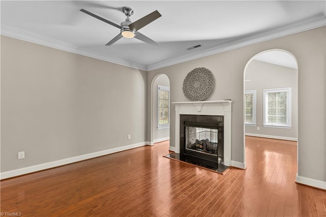 unfurnished living room featuring visible vents, crown molding, a multi sided fireplace, and hardwood / wood-style flooring