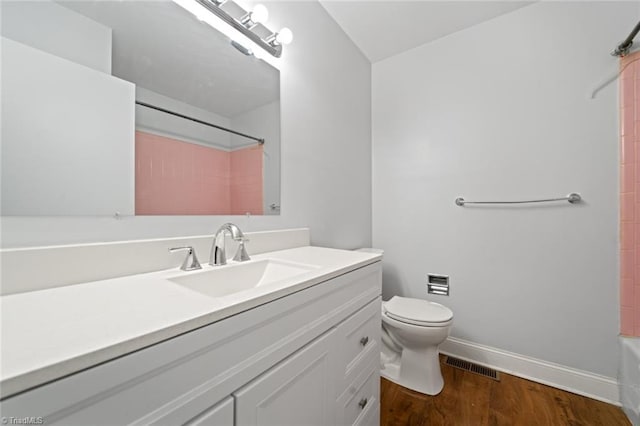 bathroom with visible vents, toilet, wood finished floors, baseboards, and vanity