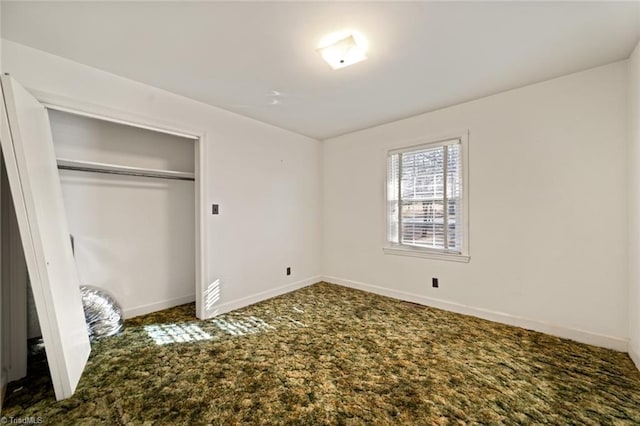 unfurnished bedroom featuring baseboards, carpet floors, and a closet