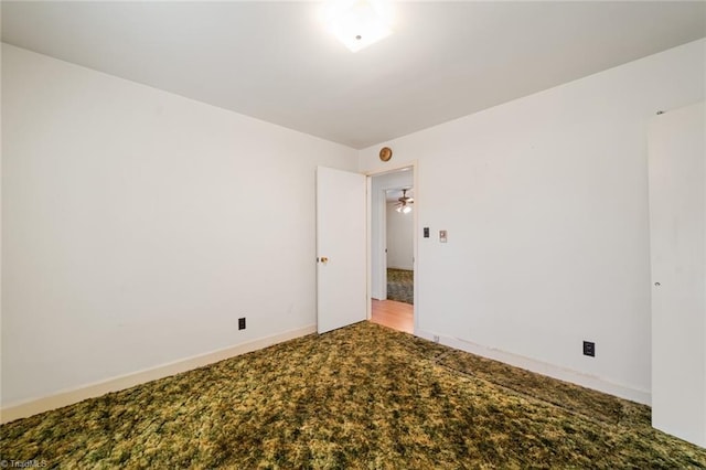 unfurnished room featuring carpet and baseboards