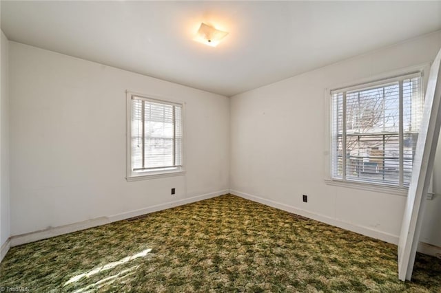 carpeted spare room featuring baseboards