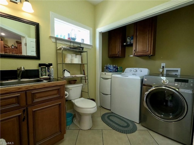 clothes washing area featuring washer and clothes dryer and light tile patterned floors