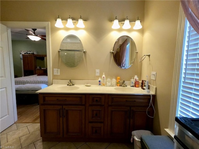 ensuite bathroom featuring ceiling fan, double vanity, and tile patterned flooring
