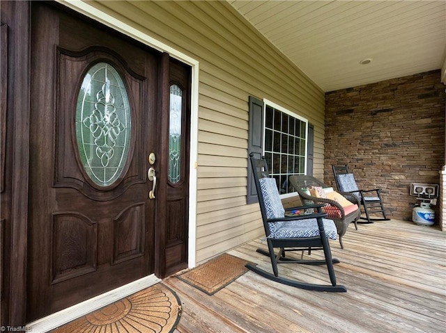 view of exterior entry featuring covered porch