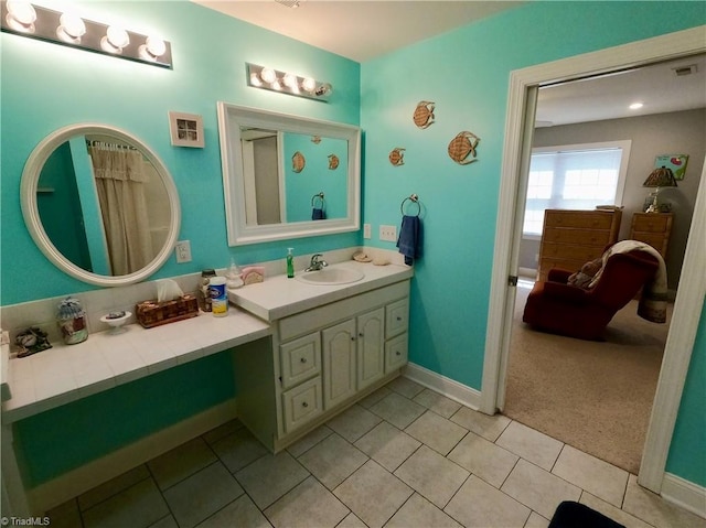 bathroom featuring tile patterned flooring, baseboards, and vanity