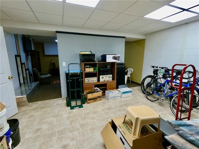 finished below grade area featuring concrete block wall and a drop ceiling