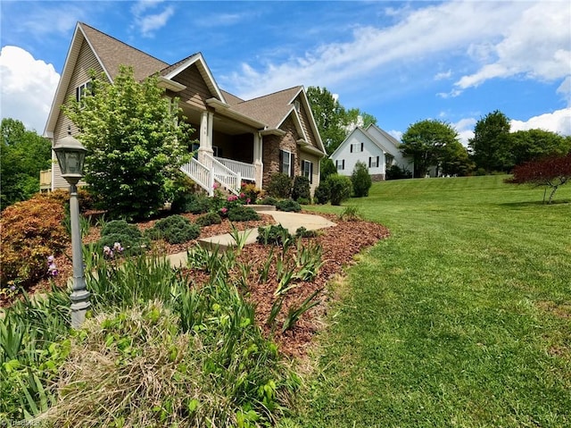 view of home's exterior featuring covered porch, a yard, and a shingled roof