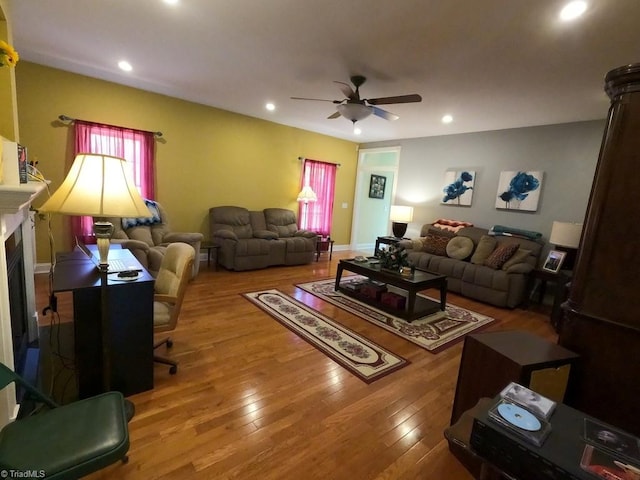 living area featuring a ceiling fan, hardwood / wood-style floors, recessed lighting, a fireplace, and baseboards