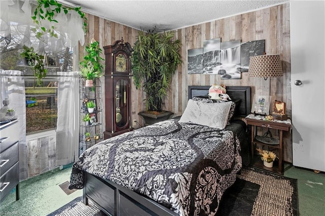 carpeted bedroom featuring wooden walls and a textured ceiling