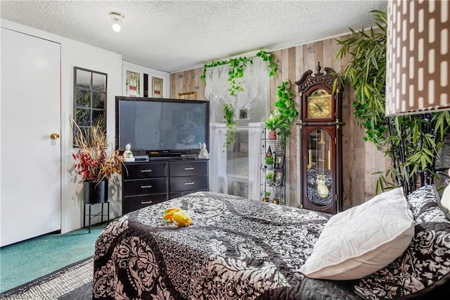 bedroom with wooden walls, a textured ceiling, and carpet