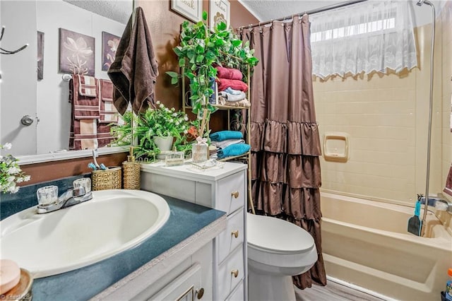 full bathroom with shower / tub combo, vanity, toilet, and a textured ceiling