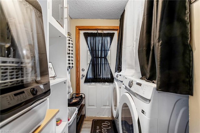 laundry room featuring hardwood / wood-style flooring, washing machine and dryer, and a textured ceiling