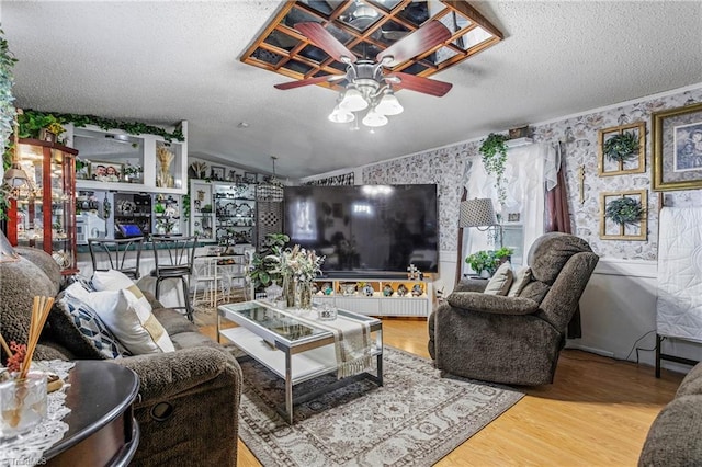 living room featuring lofted ceiling, ceiling fan, wood-type flooring, a textured ceiling, and bar area