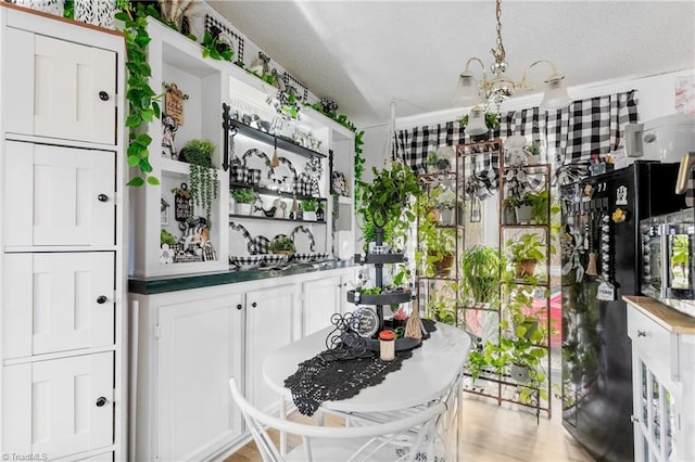 kitchen featuring a notable chandelier, crown molding, and white cabinets