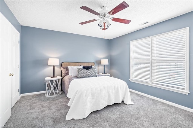 bedroom featuring a textured ceiling, baseboards, and carpet flooring