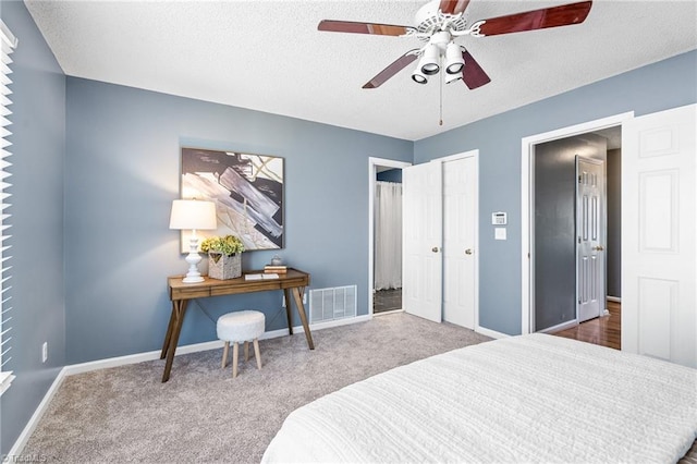 bedroom with carpet floors, baseboards, visible vents, and a textured ceiling