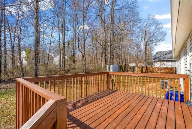 deck with an outdoor structure, a storage unit, and fence