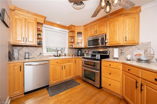 kitchen featuring decorative backsplash, stainless steel appliances, light hardwood / wood-style flooring, ceiling fan, and sink