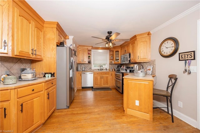 kitchen featuring appliances with stainless steel finishes, sink, tasteful backsplash, and light hardwood / wood-style flooring