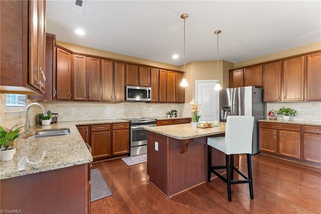 kitchen with light stone counters, stainless steel appliances, dark wood-style flooring, a sink, and visible vents