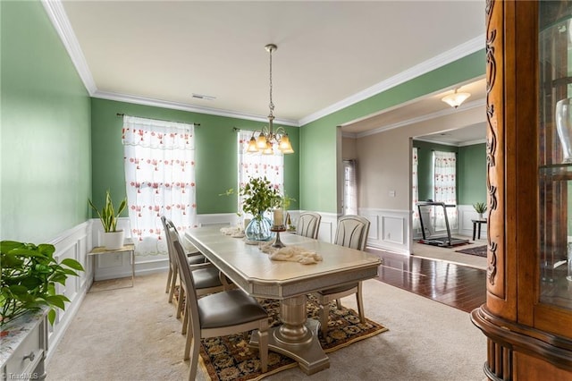 dining area featuring a wainscoted wall, carpet flooring, a chandelier, and visible vents