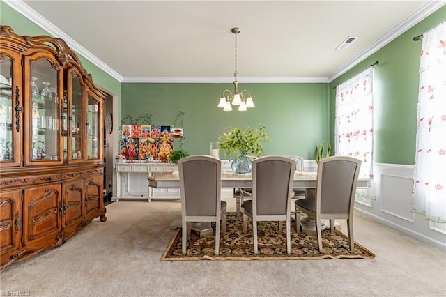 dining area featuring ornamental molding, visible vents, carpet flooring, and an inviting chandelier